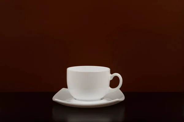 Taza de café blanco sobre mesa negra sobre fondo marrón con espacio para texto —  Fotos de Stock