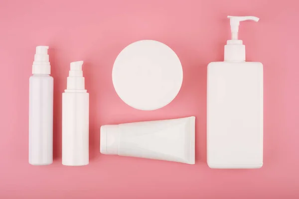 Colocação plana com conjunto de produtos cosméticos sobre fundo rosa. Conceito de beleza e cuidados com a pele — Fotografia de Stock