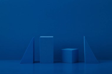 Mavi arkaplan üzerinde mavi geometrik şekiller ve metin için bir boşluk ile monokromatik soyut natürmort yaşam