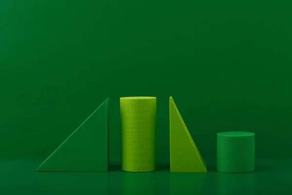Πράσινα γεωμετρικά σχήματα σε πράσινο φόντο. Αφηρημένη μονοχρωματική έννοια φόντου με χώρο για κείμενο — Φωτογραφία Αρχείου