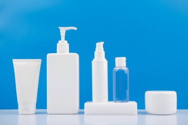 Erkekler için kozmetik ürünler seti. Cilt bakımı, hijyen ya da kozmetoloji prosedürleri. Beyaz masada mavi arka planda.