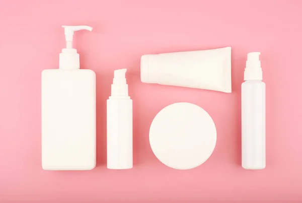 Colocação plana com produtos cosméticos para cuidados da pele em fundo rosa brilhante — Fotografia de Stock