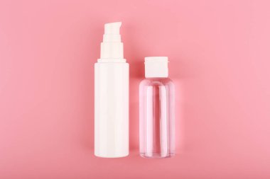 Yüz kremi, losyon, cilt losyonu ya da pembe arka planda jöle için kozmetik şişeleri. Cilt bakımı kavramı 