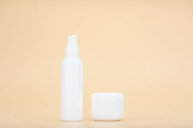 Yüz kremi ya da losyon ve göz kremi ya da dudak kremi altında bej arka planda fotokopi alanı ile. Cilt bakımı kavramı 