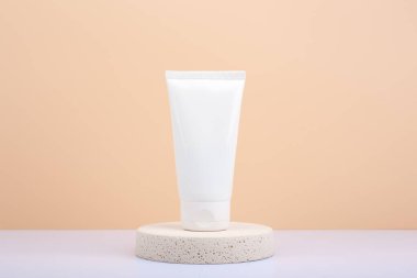 El kremi, losyon ya da yuvarlak bej podyumda fotokopi alanı olan bej arka plana sürtünme.