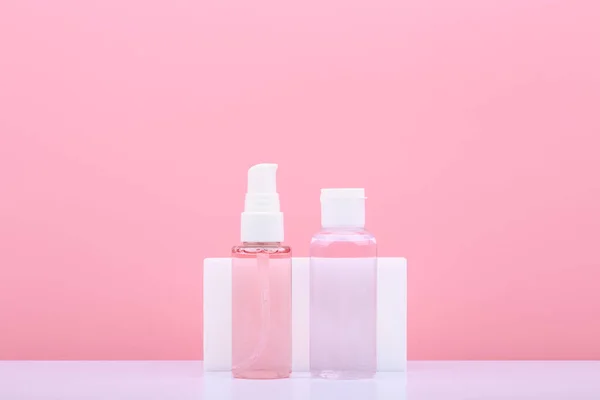 Cleaning gel or foam for face washing and cleansing and exfoliating lotion against pink background with copy space