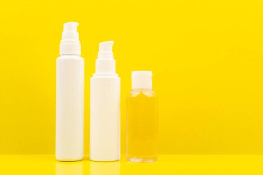 Açık sarı arka planda temizlik köpüğü, yüz kremi ve cilt losyonuyla minimalist bir hayat.