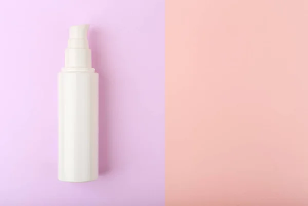 Creme facial em tubo branco sem marca contra fundo roxo e rosa com espaço de cópia — Fotografia de Stock