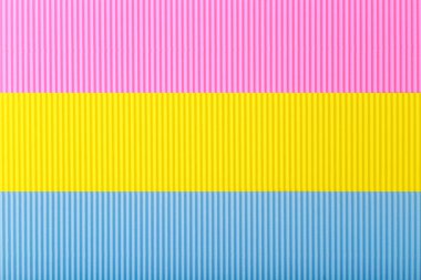 Pembe, sarı ve mavi kağıt parçalarından oluşan panseksüel bayrak. Dokulu arkaplan kavramı 