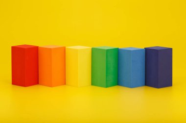 Sarı arkaplanda dikdörtgen geometrik şekillerden oluşan LGBT bayrağı. 