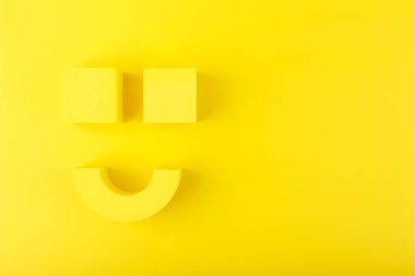 Yaratıcı düz yatıyordu mutlu bir gülümseme sembolü vardı sarı arkaplandaki sarı figürlerden yapılmıştı ve kopya alanı vardı. Gülümseme Günü kavramı, duygular, ifade ya da ruh sağlığı