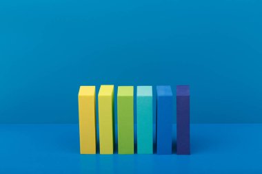 Mavi arkaplan ve fotokopi alanı olan çok renkli dikdörtgen şekillerin yüksek açılı görüntüsüne sahip soyut minimal kompozisyon. Web sitesi veya reklam paneli için şablon kavramı