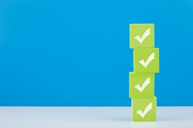 Beyaz masadaki dört açık yeşil bloktaki işaretler mavi arkaplanda kopyalama alanı olan işaretler