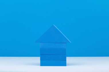 Mavi arkaplana karşı mavi bloklardan oluşan ve kopyalama alanı olan ev