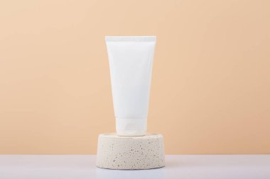 Krem, merhem, maske, pembe kaidedeki krem veya losyon ile pembe arka planda fotokopi alanı olan beyaz plastik kozmetik tüp. Manikür, el ve yüz için doğal organik cilt bakım ürünleri kavramı