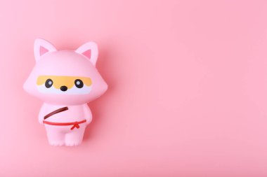 Pembe arkaplanı fotokopi alanı ile sıkıştırmak için kullanılan modaya uygun stres önleyici şirin tilki
