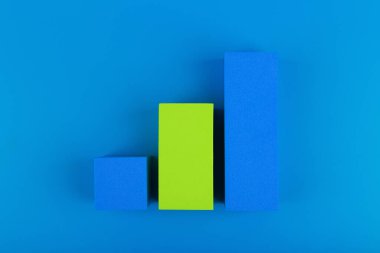 Mavi arkaplana karşı yükselen dinamik üç çubuklu iş grafiği diyagramı