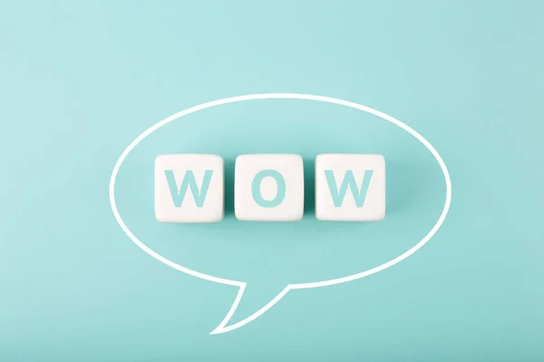 White speech bubble with wow inscription on bright tiffany blue background. Colored elegant and minimal style wow concept of expressing emotions and being excited