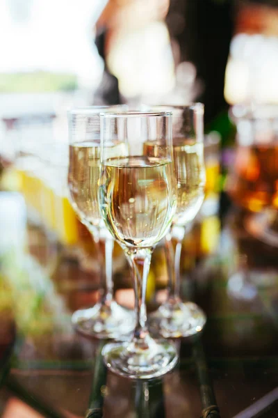 Elegant glasses with champagne standing in a row on serving table during party or celebration