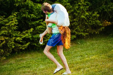 genç ve güzel bir çift holi renkli fes parkta oynarken