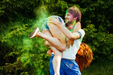 genç ve güzel bir çift holi renkli fes parkta oynarken