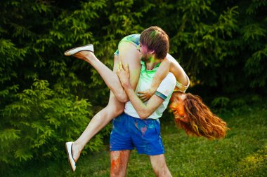 genç ve güzel bir çift holi renkli fes parkta oynarken