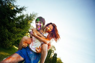 genç ve güzel bir çift holi renkli fes parkta oynarken