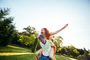 genç ve güzel bir çift holi renkli fes parkta oynarken