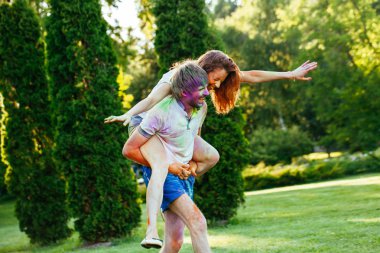 genç ve güzel bir çift holi renkli fes parkta oynarken