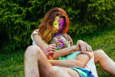 genç ve güzel bir çift holi renkli fes parkta oynarken