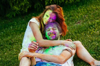 genç ve güzel bir çift holi renkli fes parkta oynarken