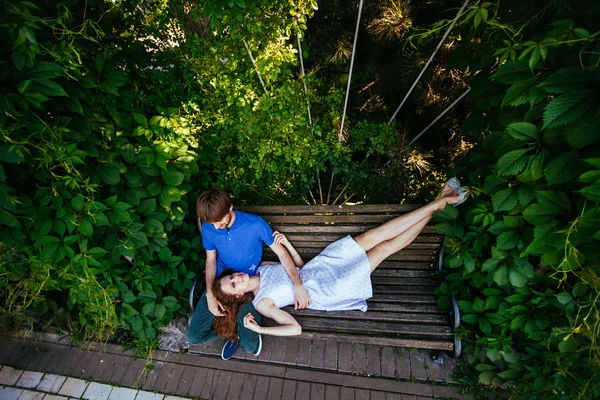 Casal jovem em um banco de parque — Fotografia de Stock