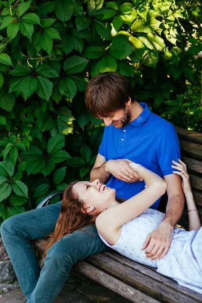 Casal jovem em um banco de parque — Fotografia de Stock