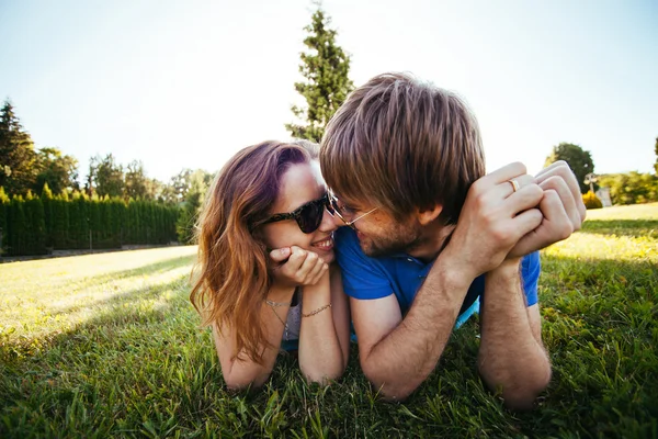 Couple amoureux couché sur l'herbe verte — Photo