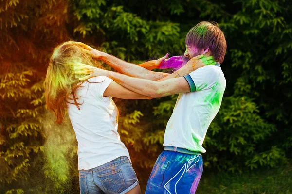 Jovem e belo casal brincando no parque em holi cor fes — Fotografia de Stock