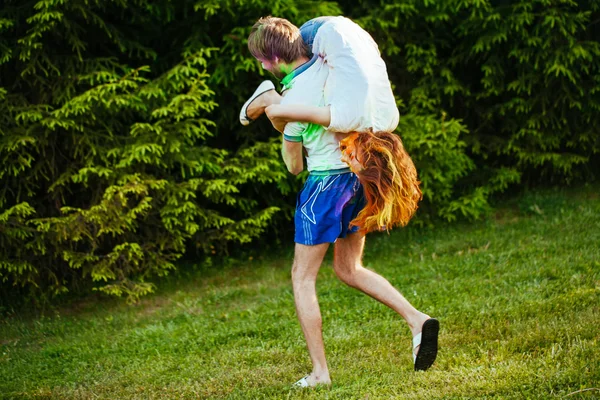 genç ve güzel bir çift holi renkli fes parkta oynarken