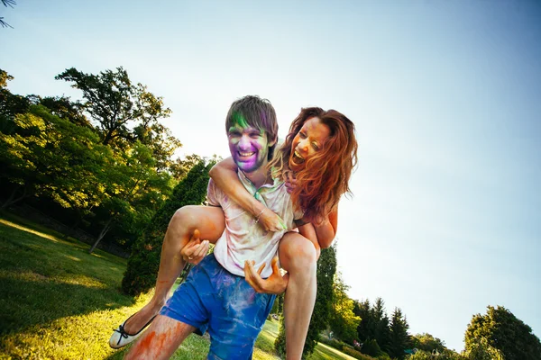 Young and beautiful couple playing in the park on holi color fes — Stock Photo, Image