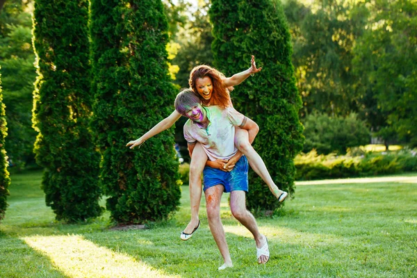 Young and beautiful couple playing in the park on holi color fes — Stock Photo, Image