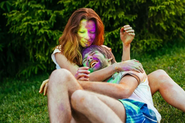 Jovem e belo casal brincando no parque em holi cor fes — Fotografia de Stock