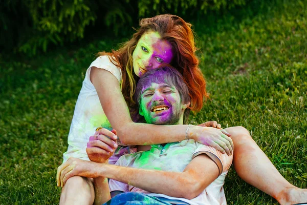 Jovem e belo casal brincando no parque em holi cor fes — Fotografia de Stock