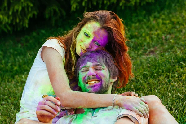 Jovem e belo casal brincando no parque em holi cor fes — Fotografia de Stock