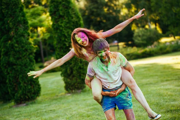 Joven y hermosa pareja jugando en el parque en holi color fes —  Fotos de Stock