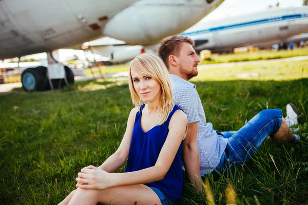 Coppia elegante in piedi vicino a un aereo in aeroporto. luna di miele — Foto Stock