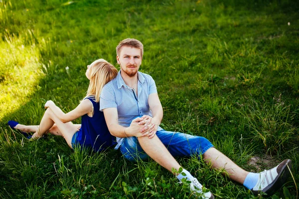 Glückliches lächelndes Paar entspannt auf grünem Rasen.park. — Stockfoto
