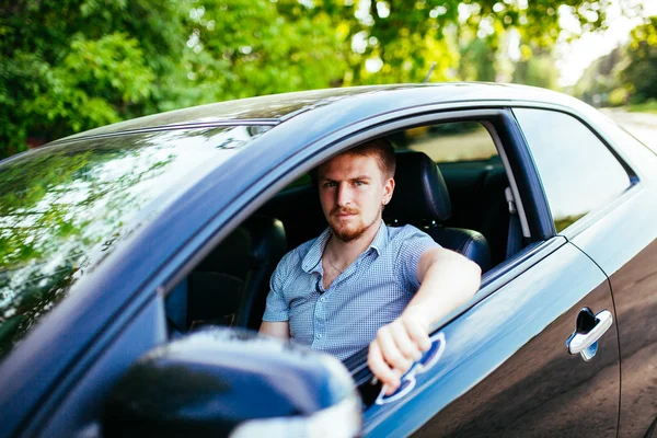 Junger Mann sitzt im Auto — Stockfoto