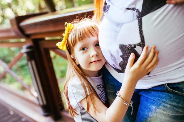 Schwangere Mutter und Tochter im Park — Stockfoto