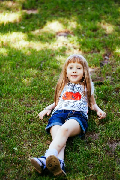 Portrait of a cute girl in a park on a meadow — Stock Photo, Image