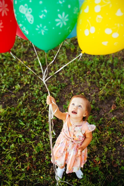 Niña de 2-3 años sosteniendo globos al aire libre. Fiesta de cumpleaños —  Fotos de Stock