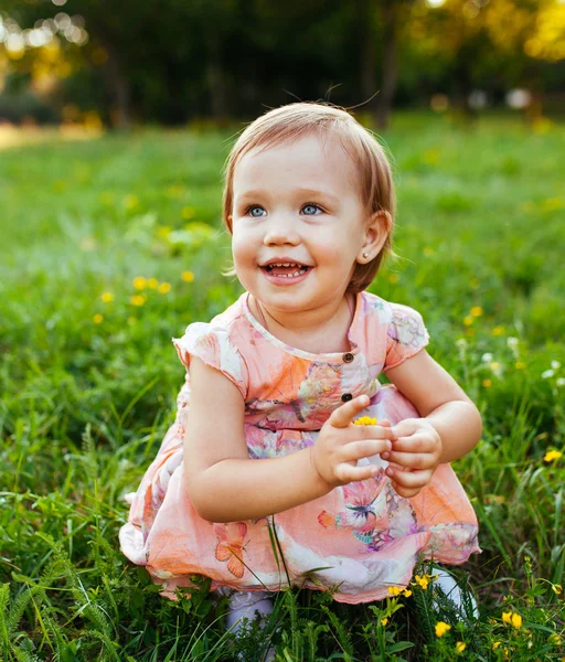 Little girl sitting on the grass. — Stock Photo, Image
