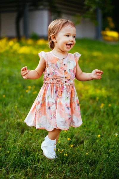 Feliz niña linda corriendo sobre el césped en el parque. Happine. —  Fotos de Stock